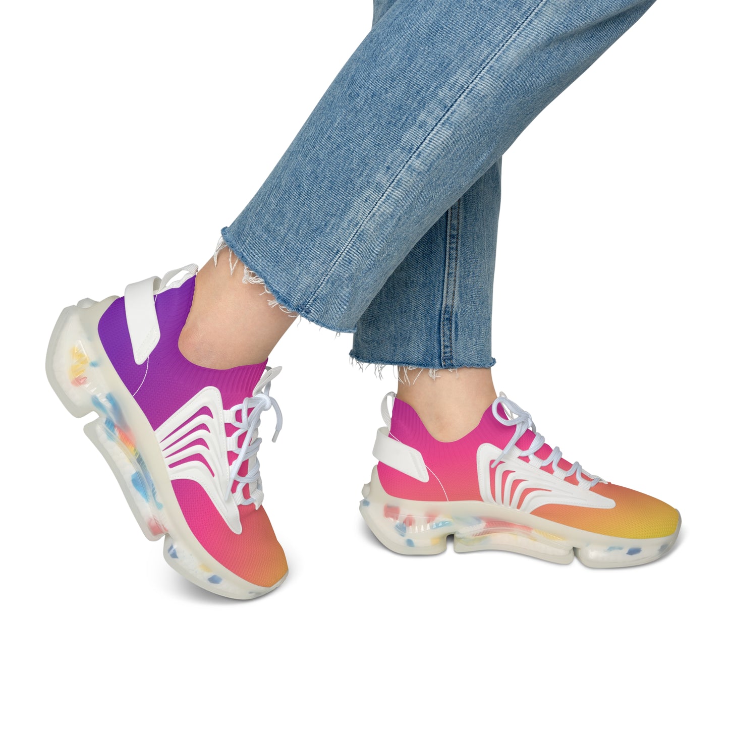 Colorful sneakers with a gradient design worn with blue jeans on a white background