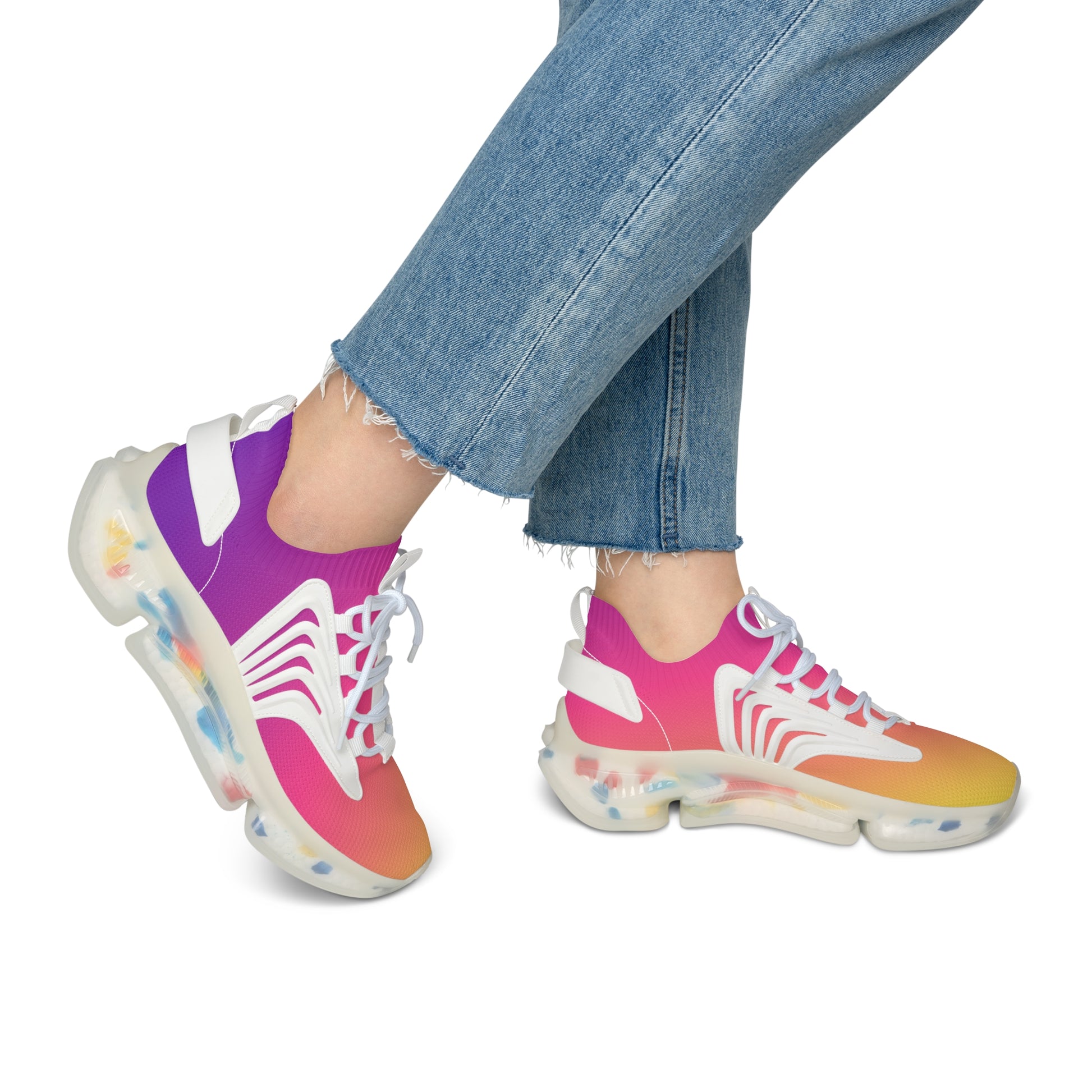 Colorful sneakers with a gradient design worn with blue jeans on a white background
