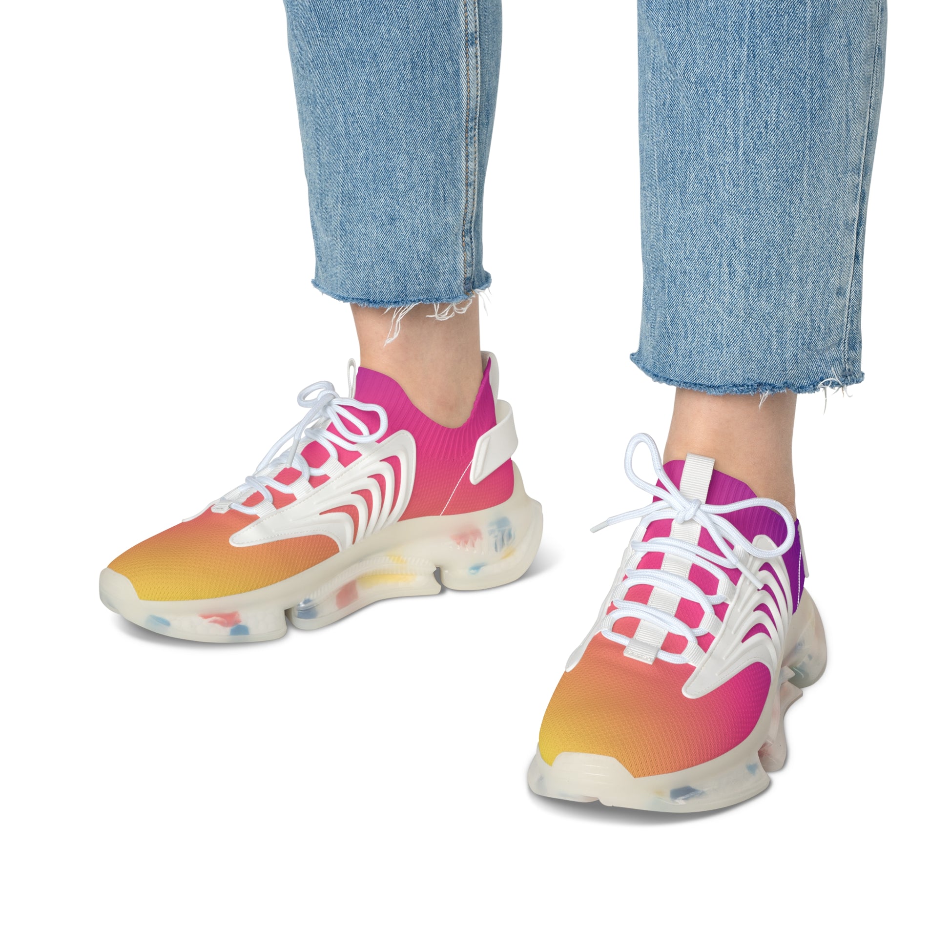 Colorful sneakers with a gradient design worn with blue jeans on a white background