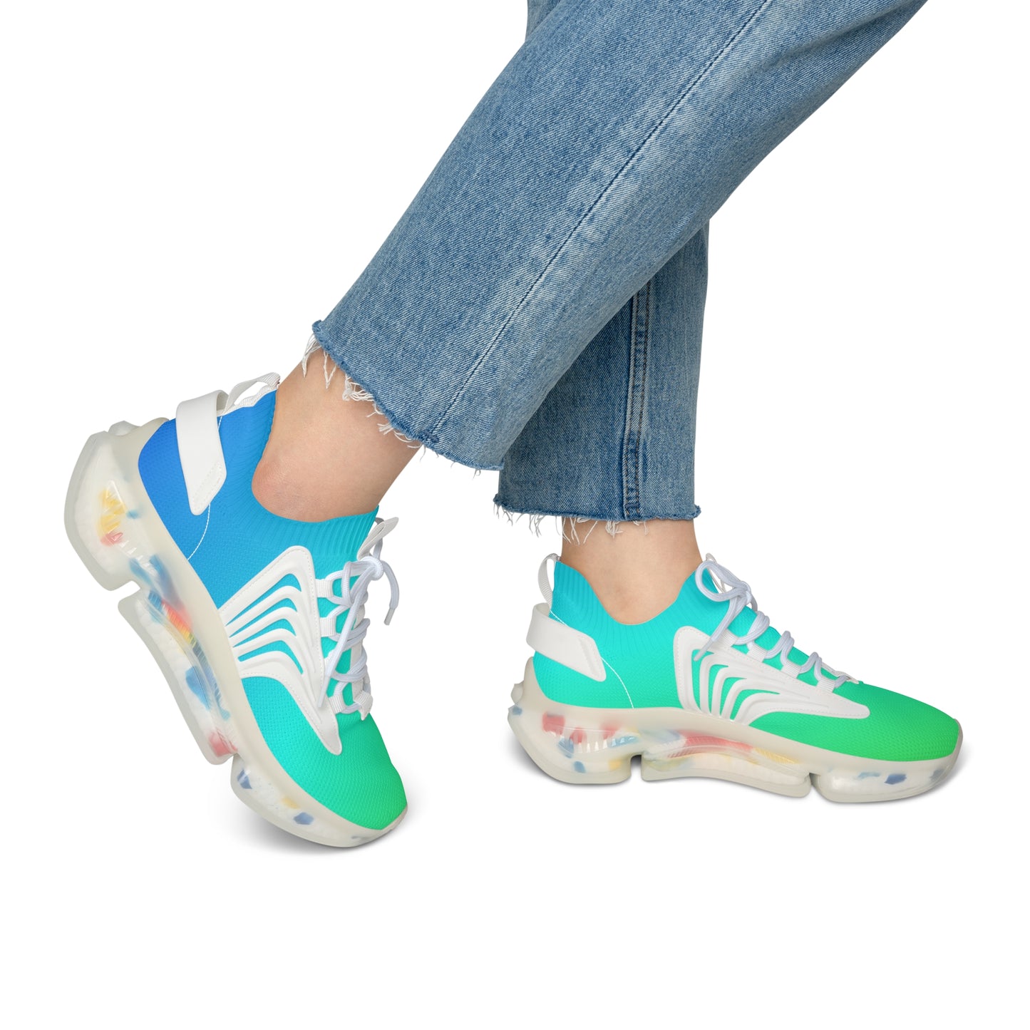Colorful sneakers with a transparent sole worn with blue jeans on a white background