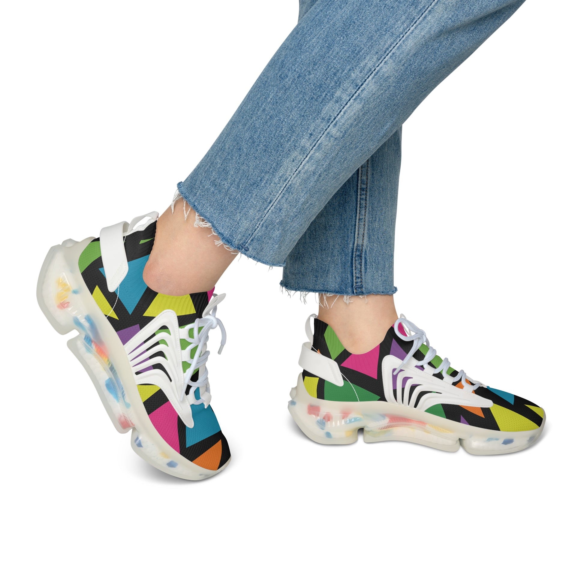 Colorful geometric-patterned sneakers worn with blue jeans on a white background