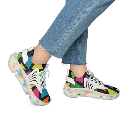 Colorful geometric-patterned sneakers worn with blue jeans on a white background