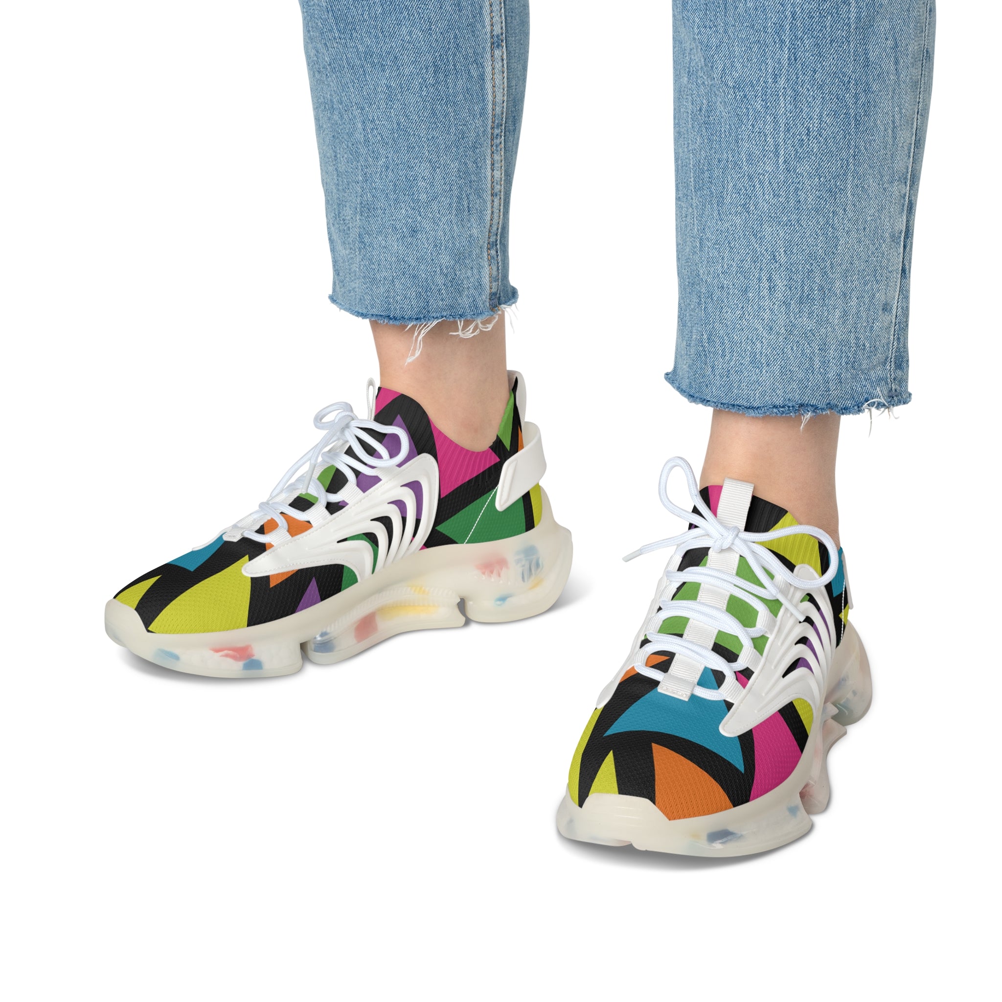 Colorful sneakers with abstract patterns worn with blue jeans on a white background