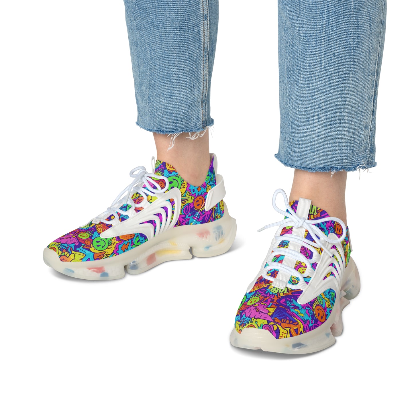 Colorful sneakers with a pattern worn by a person in blue jeans on a white background