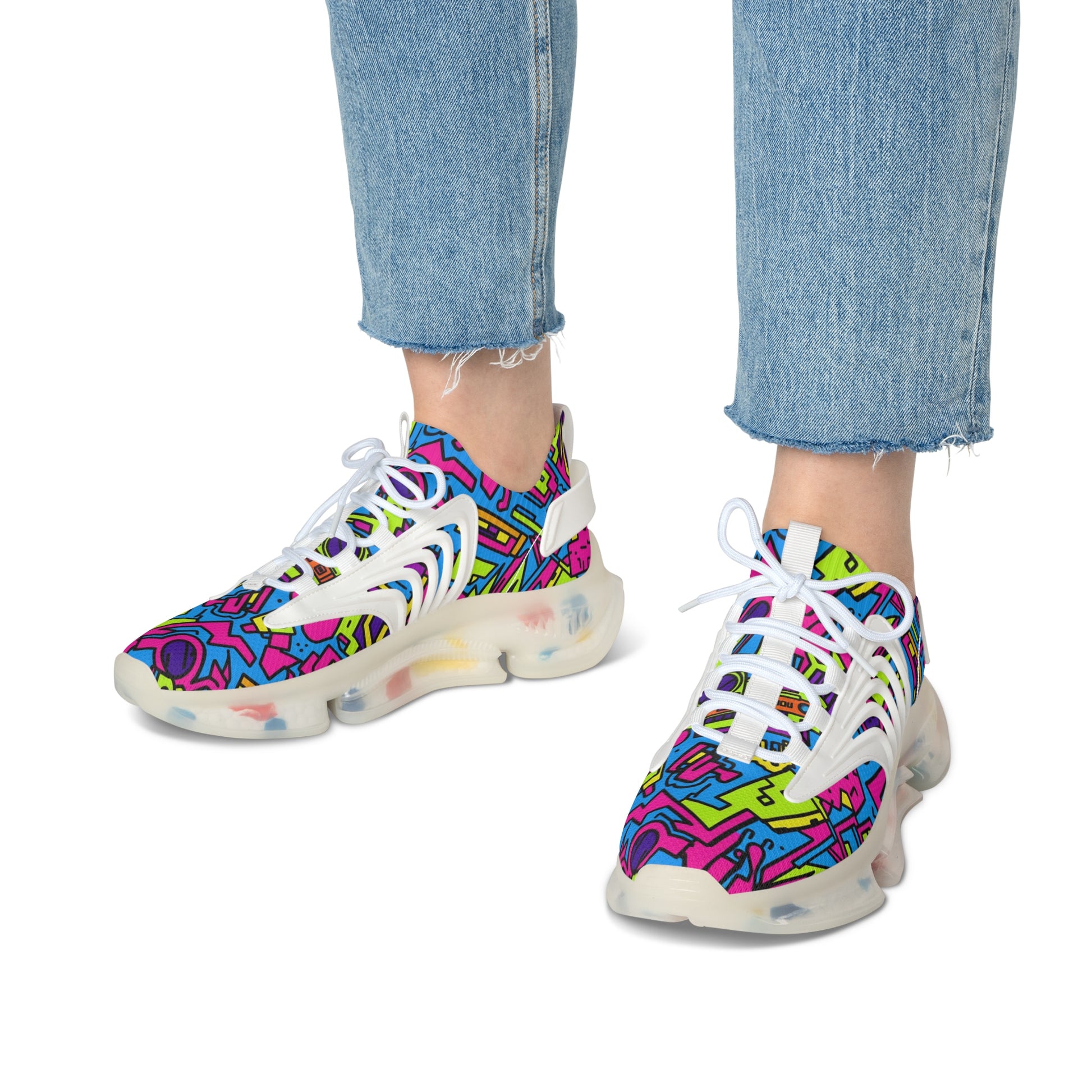 Colorful patterned sneakers worn with blue jeans on a white background